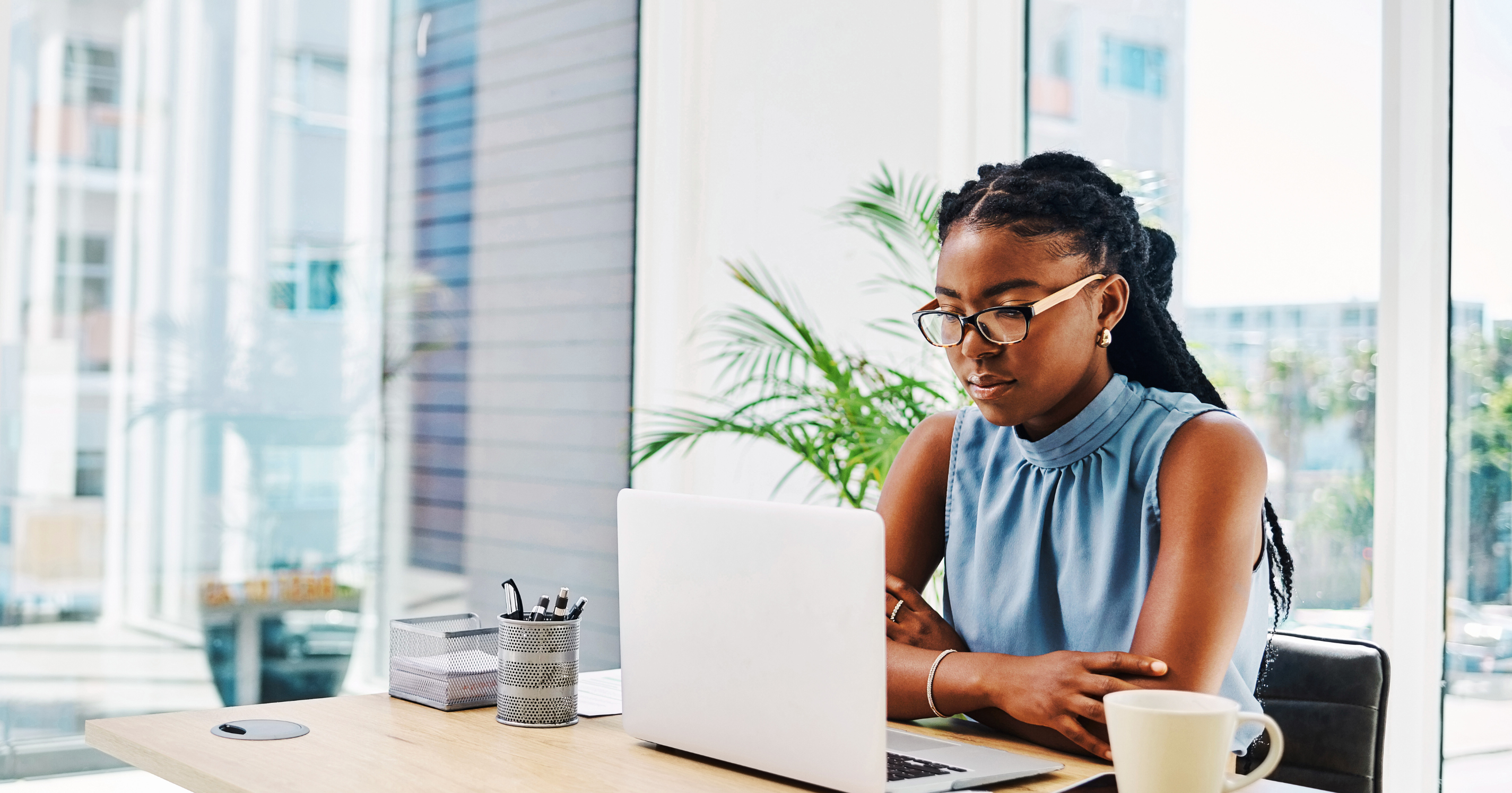 Woman sitting at desk looking at laptop